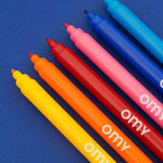OMY Ultra-Washable Markers — child colouring on an OMY poster