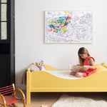 OMY Dinos — child colouring on the poster spread out on the floor