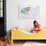 OMY Dinos — child colouring on the poster spread out on the floor