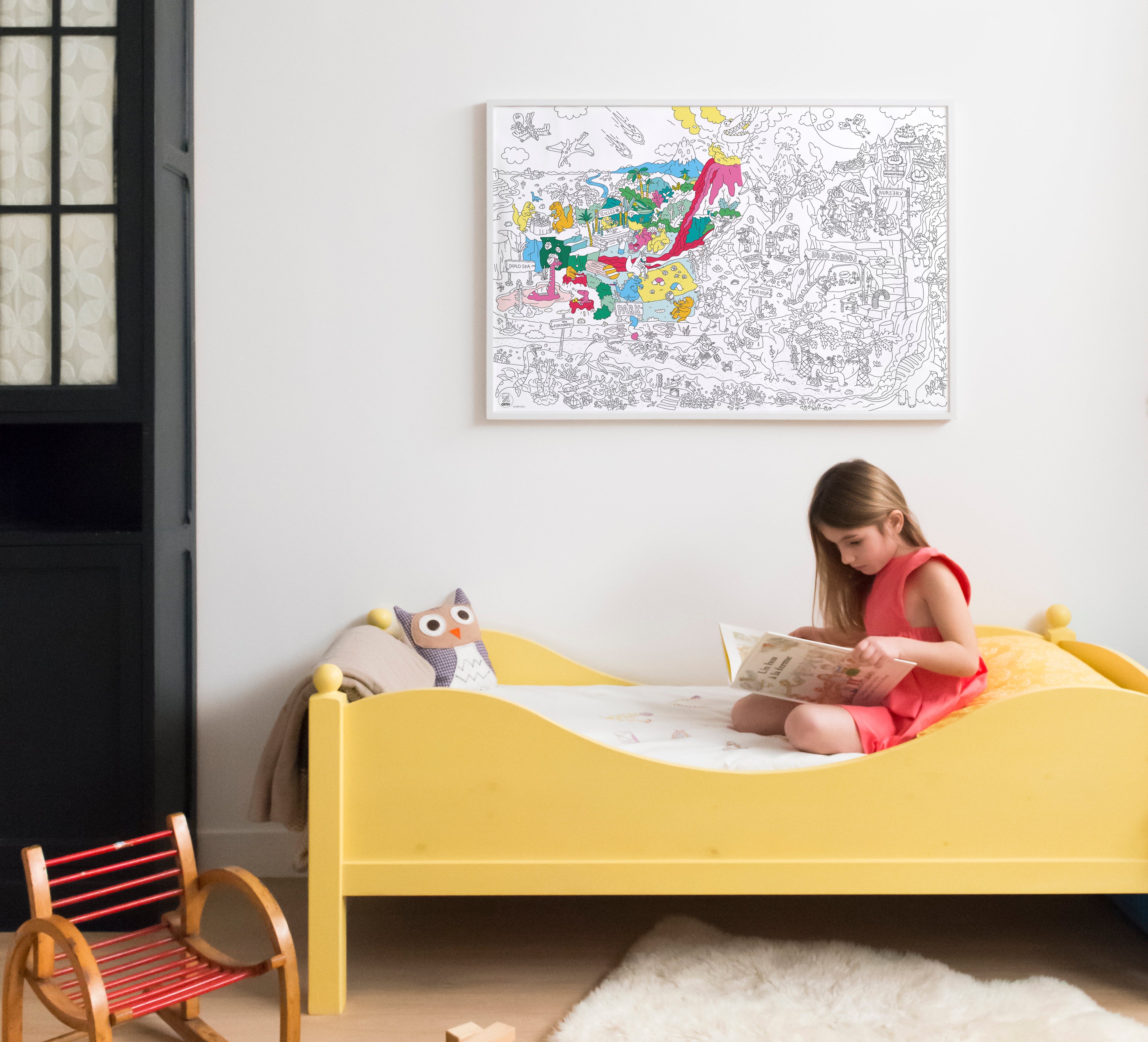 OMY Dinos — child colouring on the poster spread out on the floor