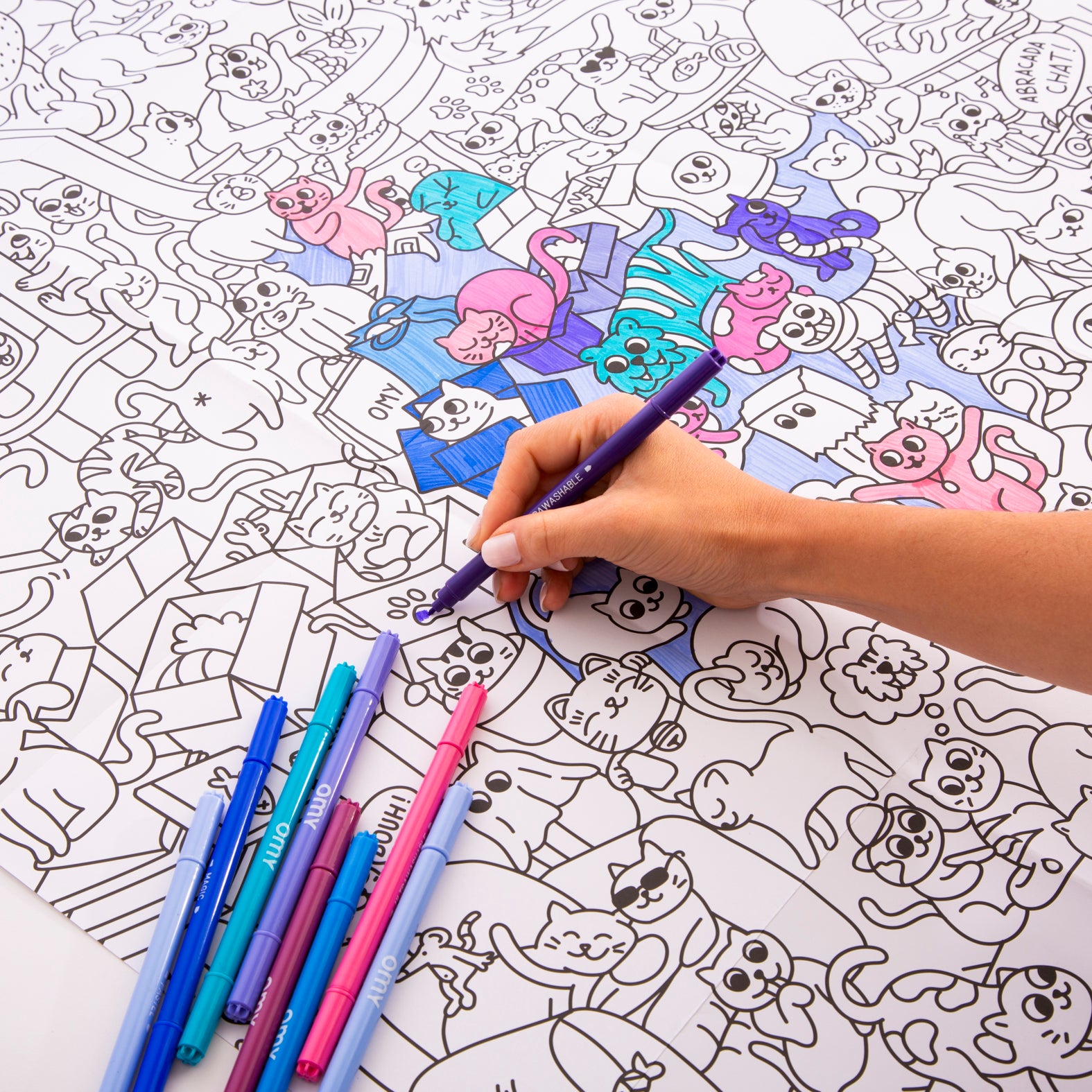 OMY Kitty — child colouring on the poster spread out on the floor