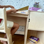 Child reading at the AGGIE desk on the AGGIE chair
